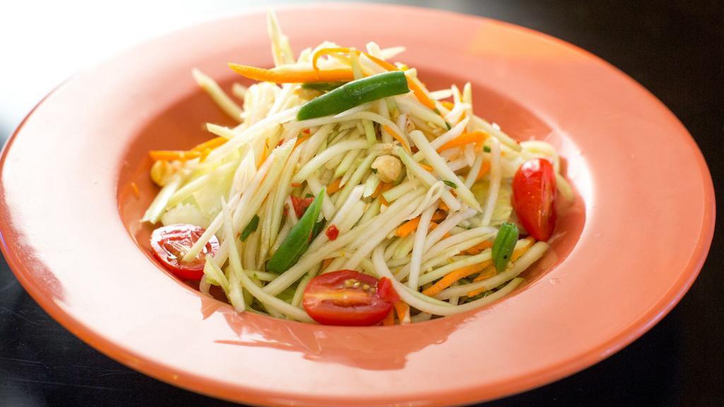 Papaya Salad · Hot. Spicy. Shredded green papaya mixed with tomatoes, string beans and peanuts in an exotic Thai spicy lime dressing.