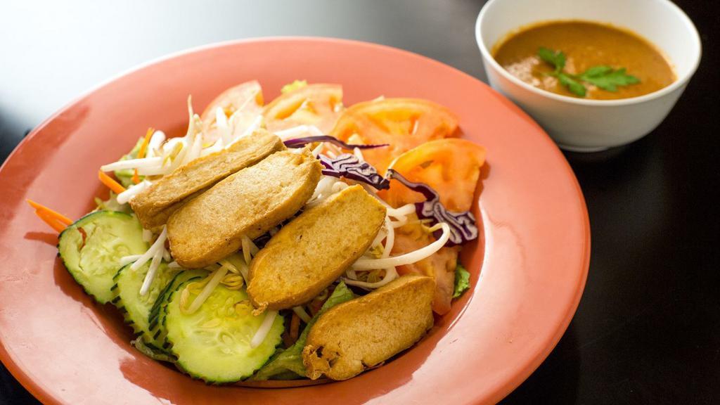 House Salad · A variety of fresh garden greens with tomatoes, onions, carrots, cucumbers and fried tofu served with homemade peanut dressing.