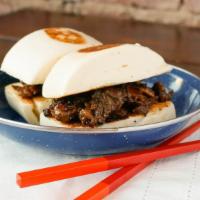 Korean Beef Bao (2 Pcs.) · Sliced marinated flank steak served in between 2 pieces of Mantou .