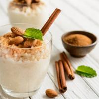 Rice Pudding · A delicious serving of rice pudding mixed with cinnamon, vanilla, and raisins.