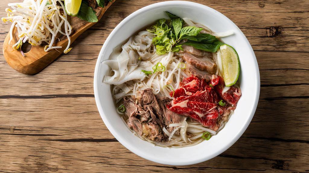 House Pho Noodle Soup / 经典火车头 · Comes with rare eye round, brisket, tripe and tendon, with rice noodles, served with beef broth, onions, scallions, and lemon, basil & bean sprouts on the side.