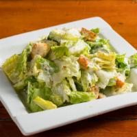 Caesar Salad · Crispy romaine hearts, parmesan flakes, garlic croutons, and creamy caesar dressing.