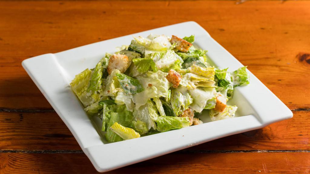 Caesar Salad · Crispy romaine hearts, parmesan flakes, garlic croutons, and creamy caesar dressing.