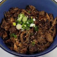 Pork Donburi · Slow-cooked marinated pork over rice with sautéed onions and house soy sauce dressing.