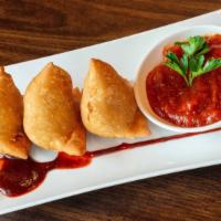 Samosa · Fried pastry dough stuffed with spiced potatoes and peas fried golden brown.