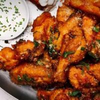 Spicy Chicken Wings · double-fried chicken wings, honey calabrian chili glaze, blue cheese crema