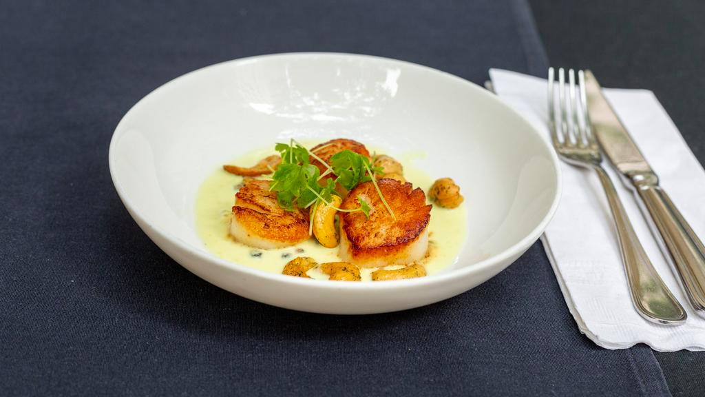 Scallops · Served with serrano pepper green curry and minted cashews.