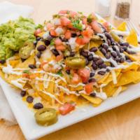 Nachos · Tortilla chips topped with black beans, melted jack & cheddar cheese, crema, guacamole & pic...