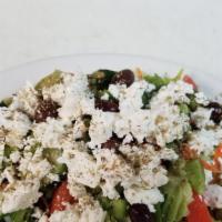 Greek Salad · Mixed greens, stuffed grape leaves, feta, and kalamata olives.