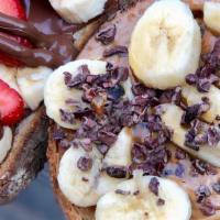 Banana Almond Toast · Almond butter, banana, cacao nibs, and honey over rustic balthazar bread.