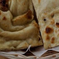 Naan · Soft leavened white flour bread baked in a clay oven. Indian bread prepared in a clay oven.