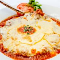 Costoletta Parmigiana · Veal chop pounded in a tomato sauce, with melted mozzarela and served over linguine