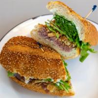 The Droopy · Grass fed roast beef, French's fried onions, arugula, and horseradish mayo on sesame seeded ...