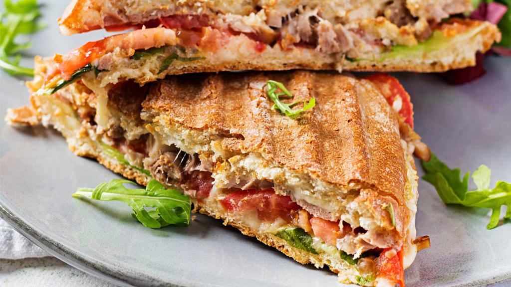 The Italiano Panini · Fresh, grilled pesto chicken, roasted red peppers, fresh mozzarella cheese, and pesto sauce drizzled on a Focaccia Bread.
