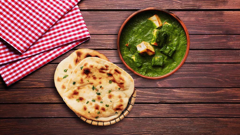 Spinach Cottage Cheese & Naan Bread · Flavorful yet spicy spinach curry with fresh chunks of cottage cheese, served with naan bread.