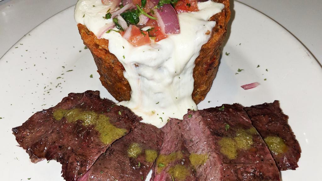 Steak Mofongo · Plantains are fried, then mashed with pork rinds, salt, garlic, and oil. Topped with mozzarella cheese sauce & pico de gallo. Served with grilled  churrasco and chimichuri sauce.