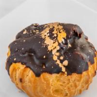 Profiterole · French pastry ball with custard cream garnished with chocolate sauce.