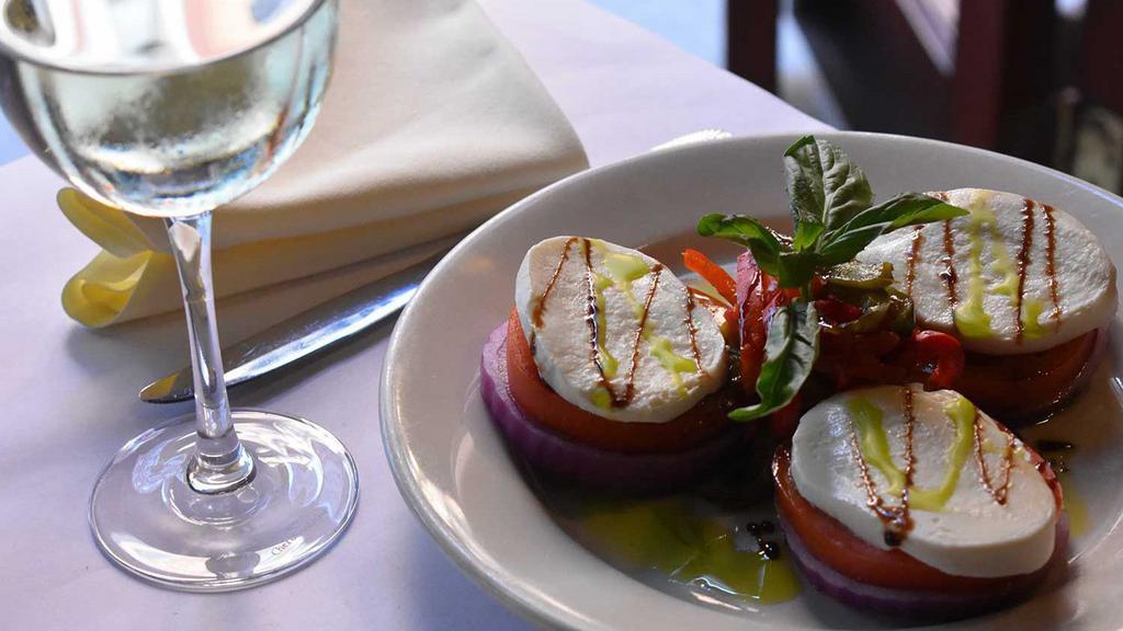 Caprese · Fresh mozzarella cheese, vine ripened beefsteak tomatoes, roasted peppers, and garlic with a drizzle of olive-pesto oil and balsamic.