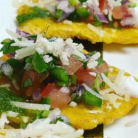 Tostones · Fried green plantains with pico de gallo, cilantro pesto, garlic, parmesan cheese and a touc...