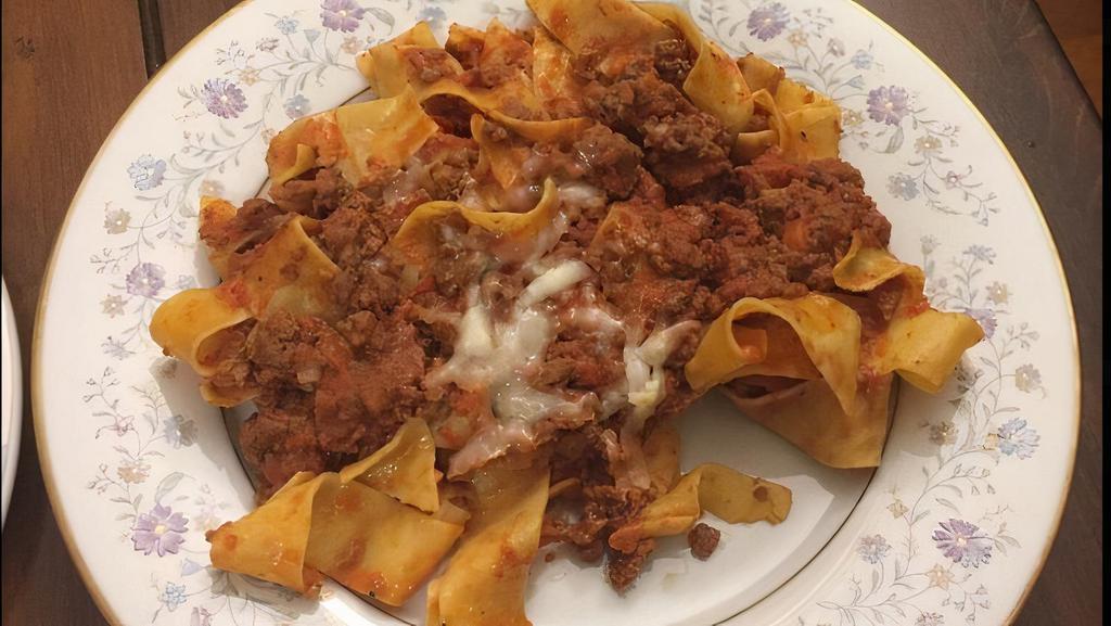 Pappardelle Alla Bolognese · Flat ribbon pasta in a veal and beef ragu.
