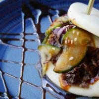 Two Bulgogi Beef Buns · Two baos with thinly sliced korean style beef, cabbage, black sesame seeds, and sauce