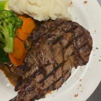 Rib Eye Steak · Grilled to your liking, topped with onions and mushrooms served with mashed potatoes.
