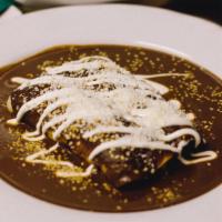 Enchiladas De Mole · Corn tortillas filled with roasted chicken, cheese, topped with our authentic mole sauce, se...