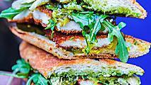 Schnitzel Sandwich · Fried chicken cutlet, sweet relish, pickles, house-made pesto sauce, honey mustard, roasted fennel, arugula salad, on a toasted baguette!.