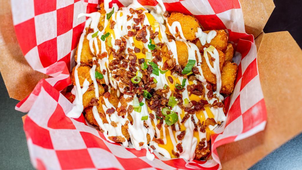 Baked N Loaded · Huntington Village favorite! Tots, sour cream, whiz and bacon.