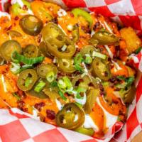 Asada Tots · Tots, guac, Cheddar, sour cream, jalapeños, bacon bits, topped with chipotle sauce.