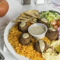 Spicy Falafel Hummus Platter · Falafel over hummus and topped with spicy red sauce.  Served with cucumber & tomato salad, l...