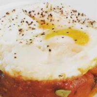 Huevos Con Pisto · Two crispy eggs sunny side up over stewed vegetables.