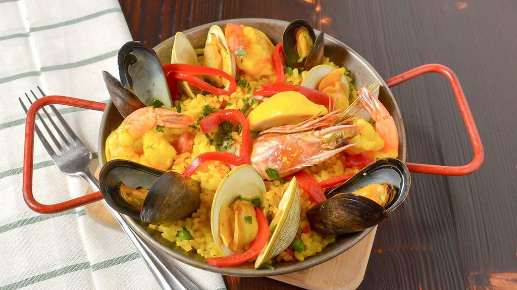 Seafood Paella · Traditional Spanish Paella: bomba rice with clams, mussels, shrimp, calamari, prawns, and chorizo in a seafood broth.