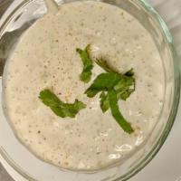 Raita · Whipped yogurt with chopped cucumbers, garnished with herbs and mild spices