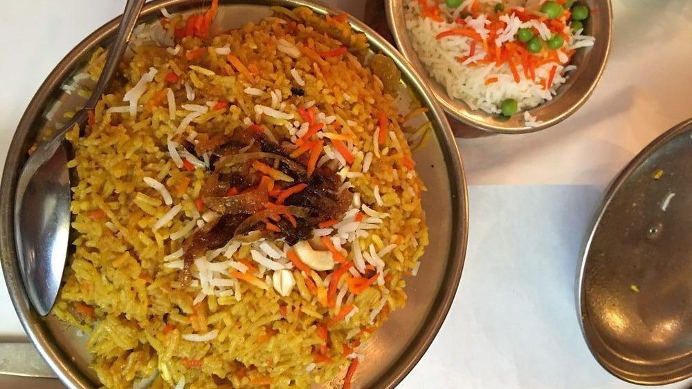 Chicken Biryani · Basmati rice with cubes of chicken cooked with saffron, onions, ginger, garlic, dried fruits, nuts, herbs, and spices.