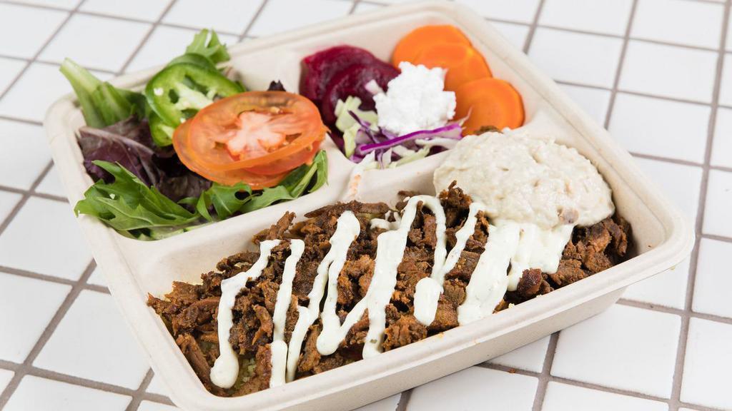 Flé-Flé Beef&Lamb Shawarma Bowl · Beef&Lamb Shawarma over rice topped with tahini sauce, a side of mix greens, cucumber pickles, hummus, onions, and fresh tomatoes.