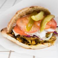 Flé-Flé Chicken Shawarma Sandwich · With garlic Sauce, cabbage, cucumber pickles, hummus, and fresh tomatoes.