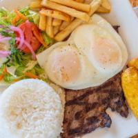 Bistec A Lo Pobre · Grilled steak, rice, plantain, eggs, and salad. / Carne asada arroz, plátanos, huevos estrel...