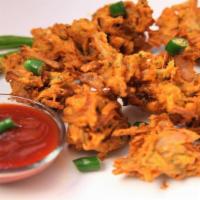 Onion Pakoras (Gf. V) · Onion and chickpea flour fritters served with tamarind chutney.