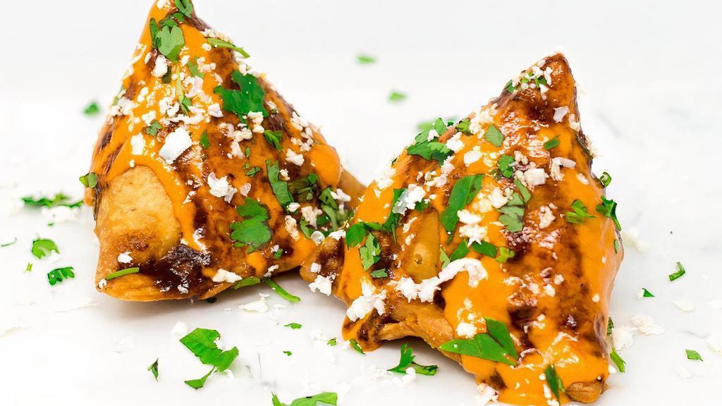 Makhani Samosa · Order of Samosa's that are covered with Dads' Sweet Makhani Sauce (sweet creamed tomato based sauce) then topped with shredded paneer cheese and finished with a drizzle of Sweet Tamarind Sauce and Cilantro and Sev.