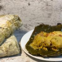 Tamal · traditional Colombian tamal with chicken, pork, carrots and corn dough.