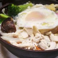 Nabeyaki Udon · A big bowl of udon noodle soup with chicken, egg, fishcakes, vegetables, and one piece of sh...