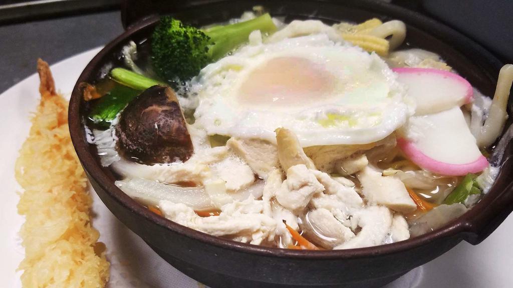 Nabeyaki Udon · A big bowl of udon noodle soup with chicken, egg, fishcakes, vegetables, and one piece of shrimp tempura.