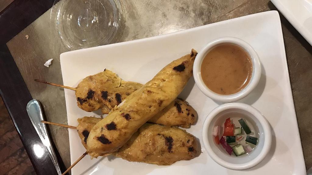 Chicken Satay · Grilled marinated chicken strips on skewers served with peanut sauce and cucumber sauce.