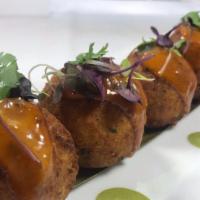 Bolitas De Yuca · Mashed yuca croquettes with chorizo & Mexican spices. Served with a honey-chipotle sauce.