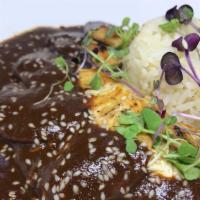 Pollo Al Mole · Chicken breast sautéed in authentic chocolate mole sauce. Served with Spanish rice, refried ...
