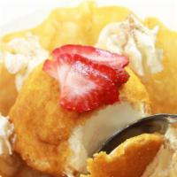 Helado Frito · Vanilla ice cream breaded with corn flakes & deep fried. Served in a tortilla shell with whi...