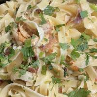 Fettuccine Carbonara · Homemade egg noodles sautéed with Italian bacon, onions, and olive oil in a delicate bechame...
