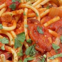 Bucatini Amatriciana · Classic Roman dish loaded with pancetta, onions, basil, plum tomatoes, and pecorino Romano..