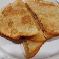 Scallion Pancakes · Savory unleavened flatbread folded with oil and minced scallions.